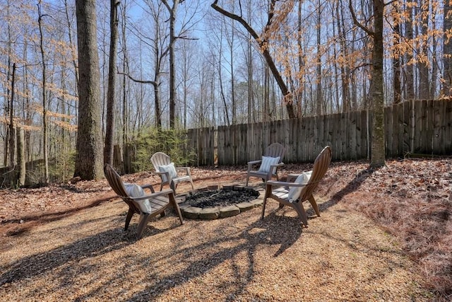 view of yard with fence and a fire pit