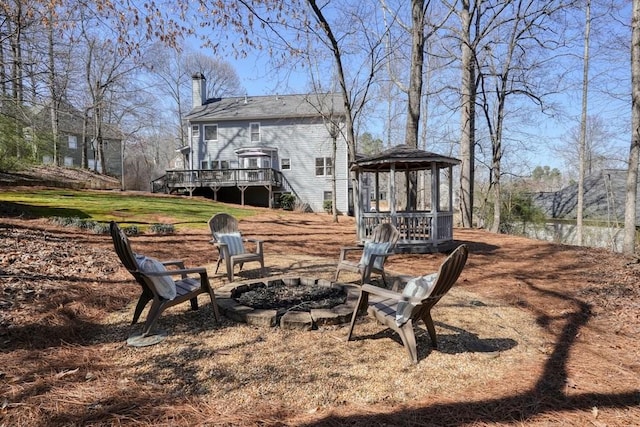 view of yard with a wooden deck and a fire pit