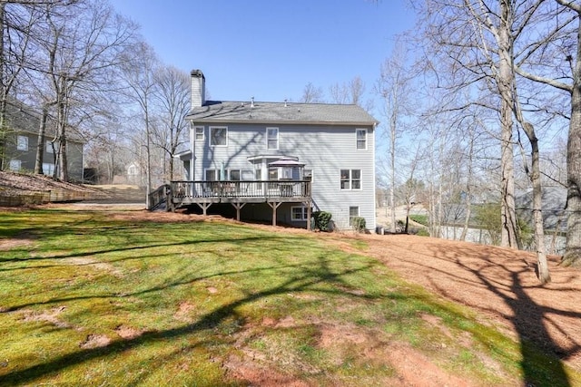 rear view of house with a wooden deck, a lawn, and a chimney