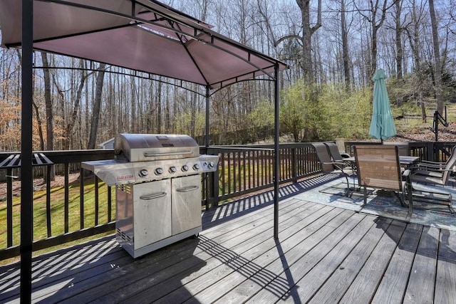 wooden terrace featuring a grill and outdoor dining space