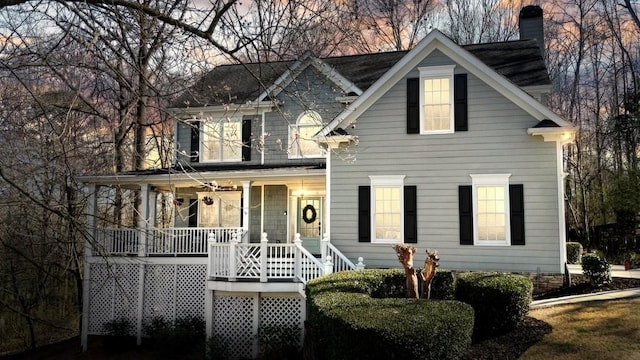 view of front of house featuring covered porch and a chimney