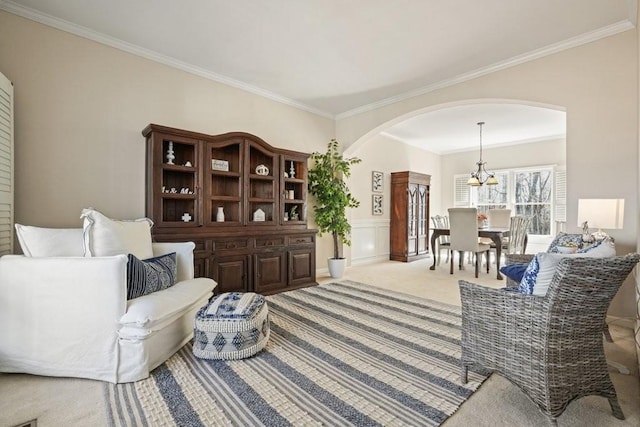 living area with a wainscoted wall, arched walkways, carpet flooring, and crown molding