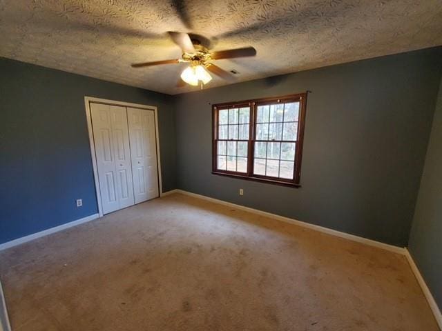 542 Banks Rd E, Fayetteville, GA 30214 - unfurnished bedroom with light colored carpet, a closet, baseboards, ceiling fan, and a textured ceiling
