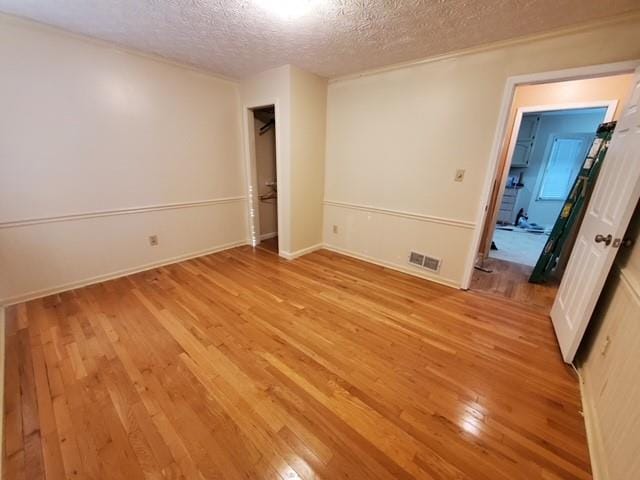 542 Banks Rd E, Fayetteville, GA 30214 - unfurnished bedroom with a textured ceiling, light wood-style floors, and baseboards