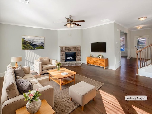 living room with a fireplace, dark hardwood / wood-style floors, ceiling fan, and crown molding