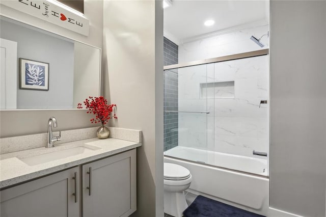 full bathroom with toilet, bath / shower combo with glass door, and vanity