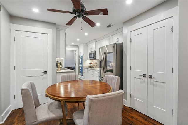 dining area with ceiling fan, dark wood-type flooring, and sink