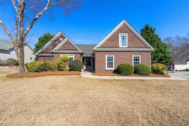 traditional-style house with brick siding and a front lawn