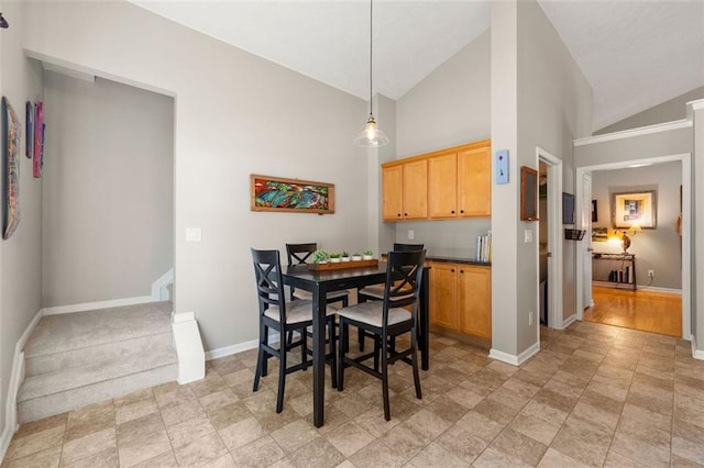 dining space with high vaulted ceiling and baseboards