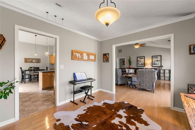 interior space with visible vents, light wood-style flooring, crown molding, and baseboards