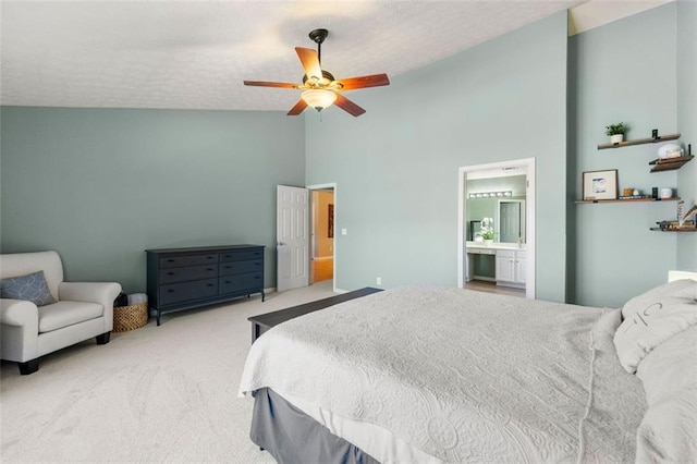 bedroom with a ceiling fan, carpet floors, high vaulted ceiling, ensuite bath, and a textured ceiling