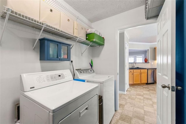 laundry area featuring washer and clothes dryer, laundry area, a textured ceiling, and a sink