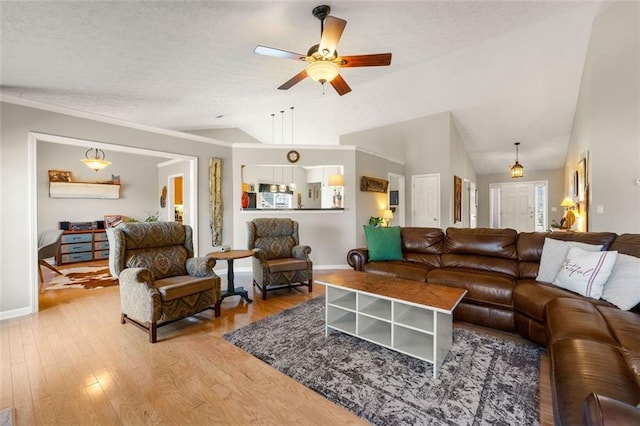 living area featuring lofted ceiling, light wood-type flooring, and a textured ceiling