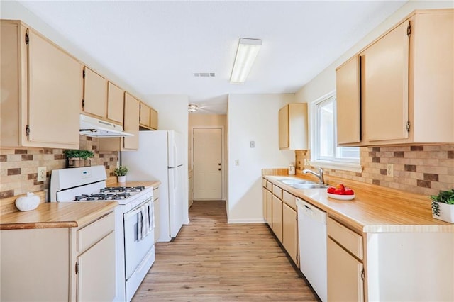 kitchen featuring white appliances, sink, light hardwood / wood-style flooring, and backsplash