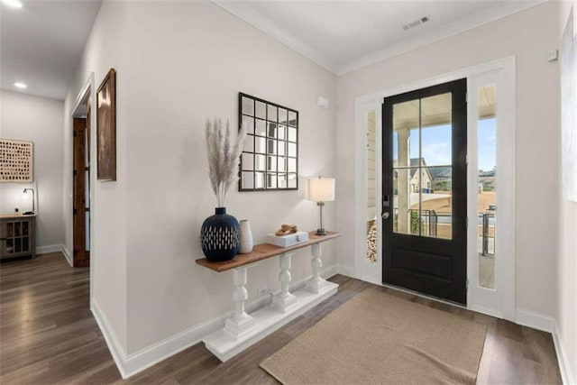 entrance foyer featuring visible vents, crown molding, baseboards, wood finished floors, and recessed lighting