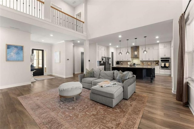 living room featuring baseboards, recessed lighting, and dark wood finished floors
