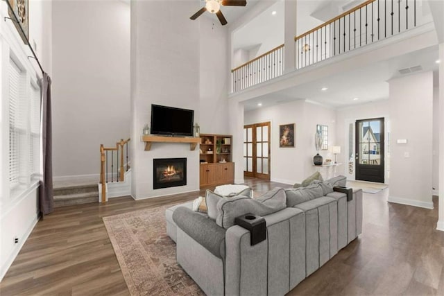 living area with baseboards, ceiling fan, and wood finished floors