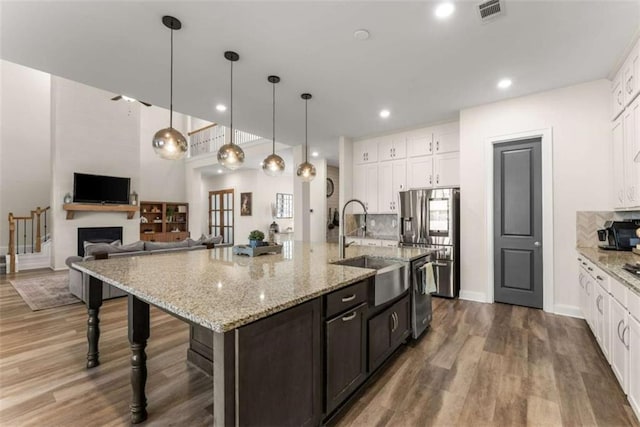 kitchen with white cabinetry, a sink, stainless steel appliances, and visible vents
