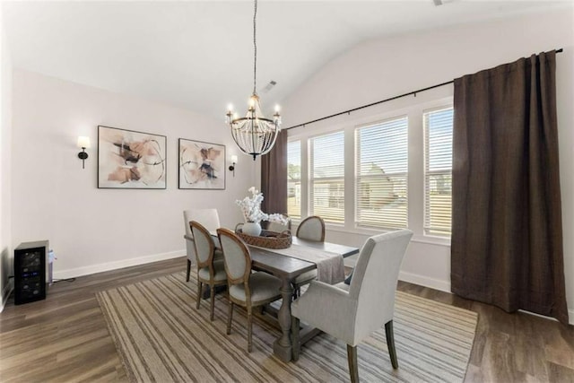 dining room featuring an inviting chandelier, baseboards, lofted ceiling, and wood finished floors