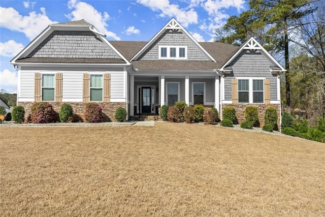 craftsman house with stone siding and a front lawn