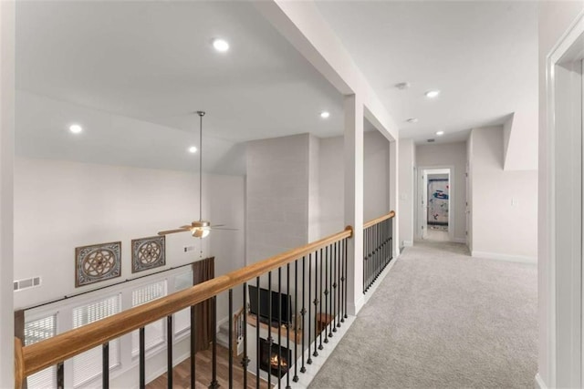 hall with lofted ceiling, carpet flooring, visible vents, and recessed lighting