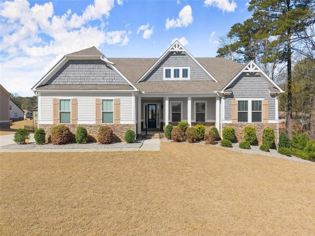 craftsman house with stone siding and a front lawn