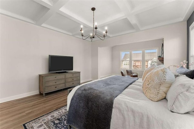 bedroom with coffered ceiling, baseboards, a chandelier, and wood finished floors