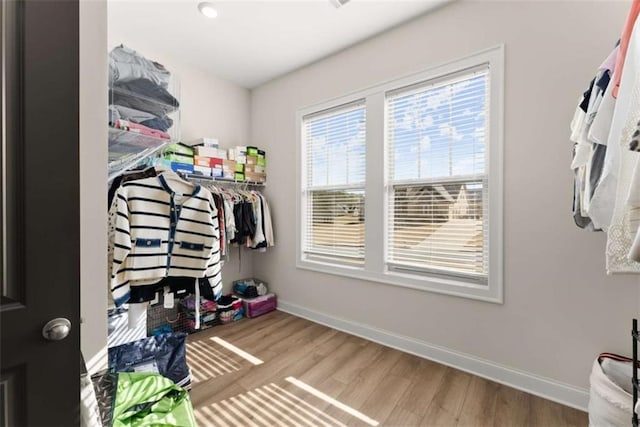 walk in closet with wood finished floors