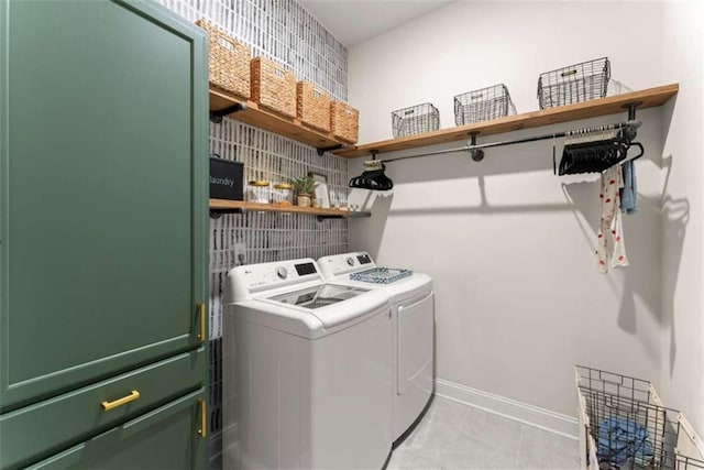 washroom with baseboards, washing machine and dryer, laundry area, and light tile patterned flooring