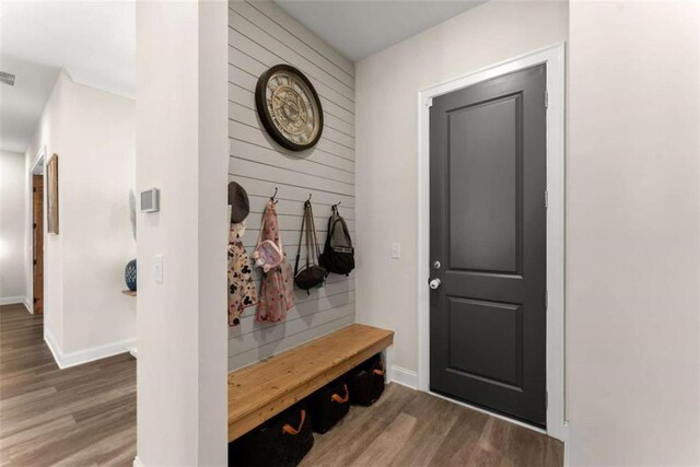 mudroom with baseboards, visible vents, and wood finished floors