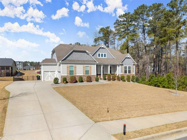 craftsman house with fence, stone siding, a garage, and concrete driveway