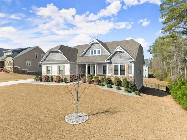 view of front of home featuring stone siding and fence