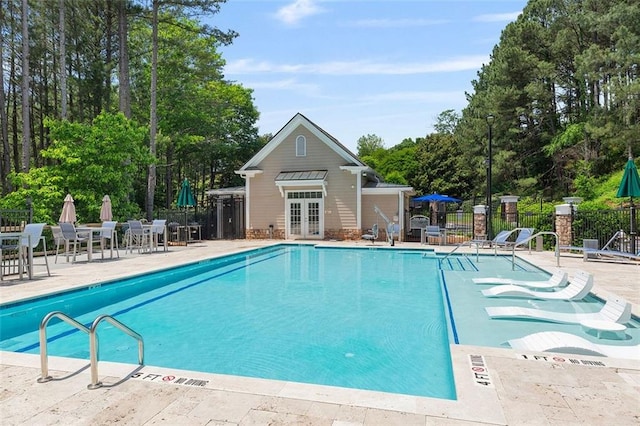 2400 Cumberland Pkwy SE Unit 613, Atlanta, GA 30339 - community pool with french doors, a patio, and view of wooded area