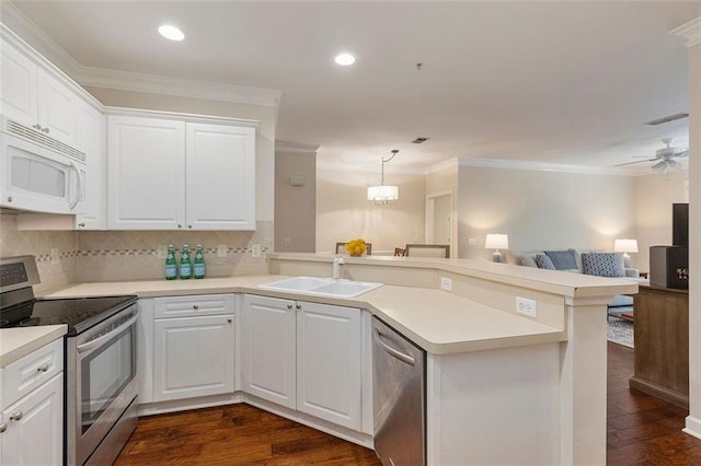 2400 Cumberland Pkwy SE Unit 613, Atlanta, GA 30339 - kitchen featuring appliances with stainless steel finishes, a sink, a peninsula, crown molding, and dark wood-style floors