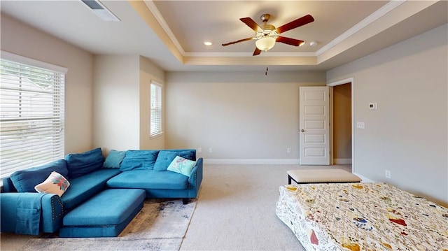 carpeted living room featuring ornamental molding, baseboards, recessed lighting, a raised ceiling, and a ceiling fan