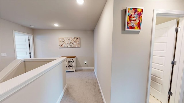 corridor featuring recessed lighting, baseboards, and light carpet