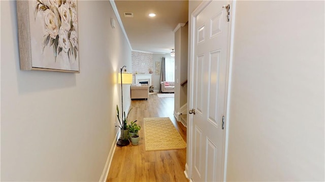 hall featuring recessed lighting, baseboards, wood finished floors, visible vents, and ornamental molding