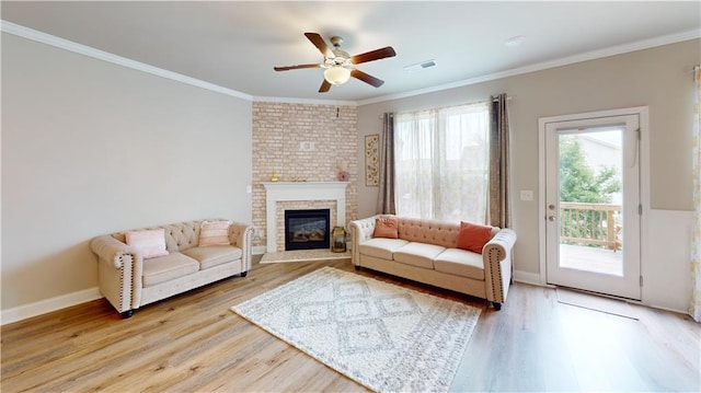 living area featuring a ceiling fan, visible vents, light wood finished floors, and a fireplace