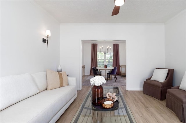 3185 Perch Dr SW, Marietta, GA 30008 - living room featuring light wood-style flooring, a chandelier, crown molding, a ceiling fan, and a textured ceiling
