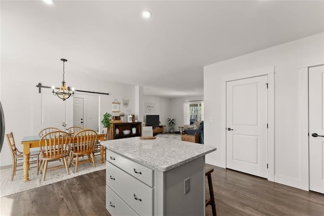 kitchen with white cabinetry, a kitchen breakfast bar, open floor plan, a center island, and pendant lighting