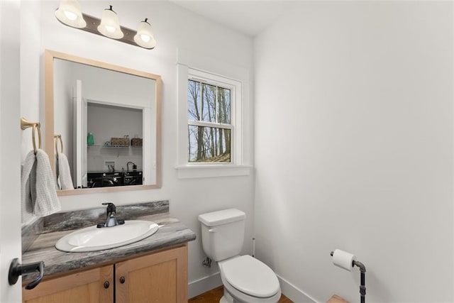 bathroom featuring vanity, toilet, and baseboards