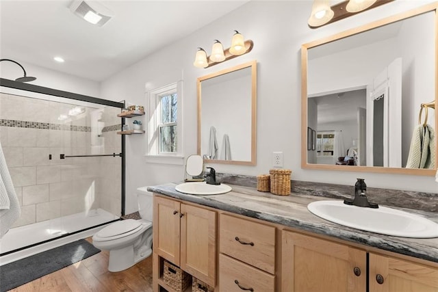 full bath with a stall shower, double vanity, a sink, and ensuite bathroom