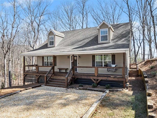 view of front of house featuring a porch, roof with shingles, and stairs