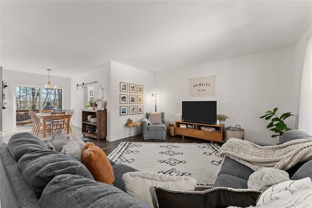 living area with a notable chandelier, baseboards, and wood finished floors