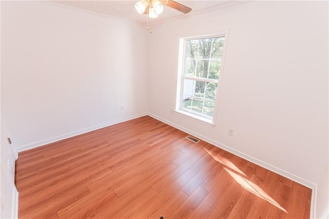 unfurnished room with visible vents, crown molding, ceiling fan, light wood finished floors, and baseboards
