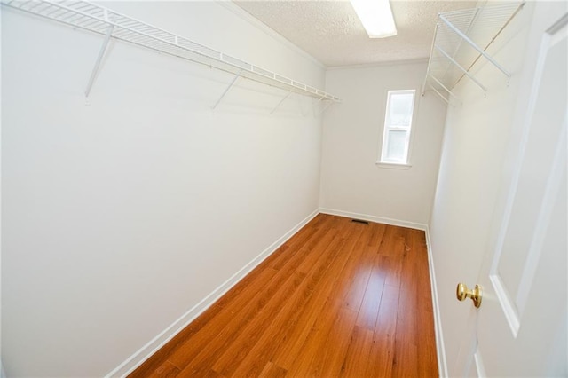 spacious closet featuring visible vents and wood finished floors