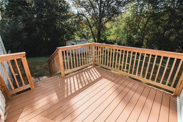 wooden terrace featuring a storage shed and an outdoor structure