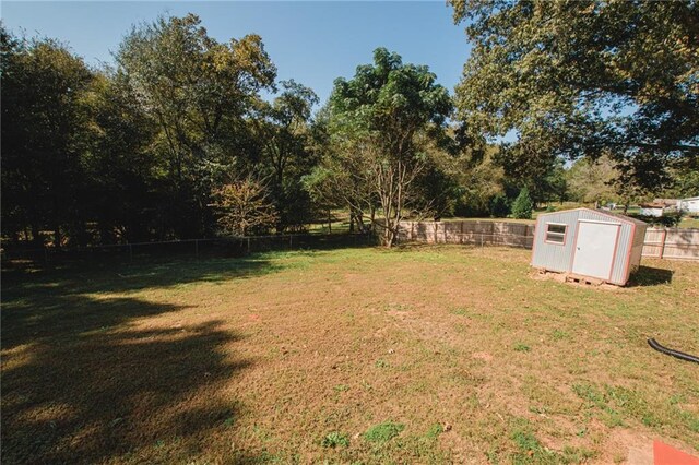 view of yard with a fenced backyard, a storage shed, and an outdoor structure