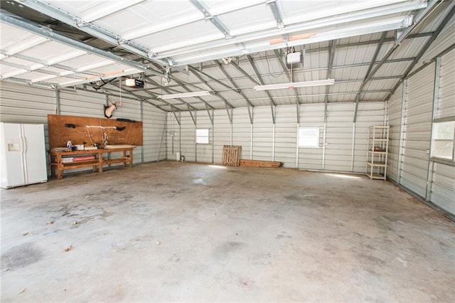 garage featuring a garage door opener, white fridge with ice dispenser, and metal wall