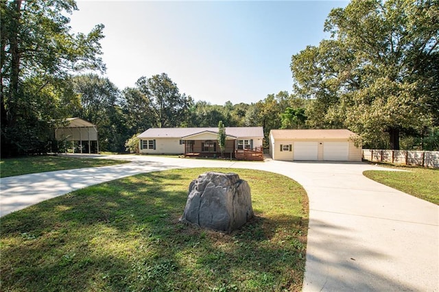 view of front facade featuring concrete driveway, a front lawn, and a detached garage